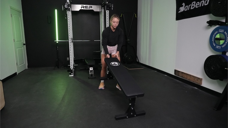 Our tester moving the Bells of Steel Flat Utility Bench into position for a workout