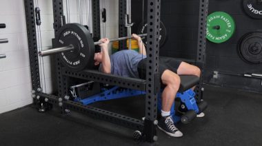 A person doing the bench press in the Barbend gym.