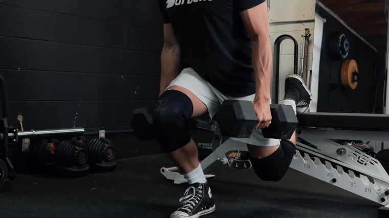 Our tester does a split squat while holding dumbbells and wearing a knee sleeve from Iron Bull.