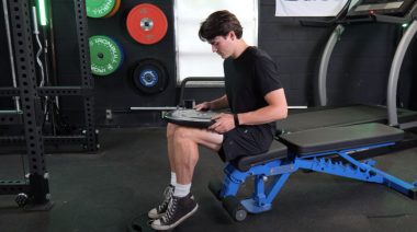 BarBend's Jake Herod doing a seated calf-raise.