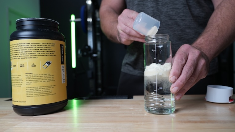 Our tester pouring a scoop of Jacked Factory Authentic ISO powder into a glass of water.