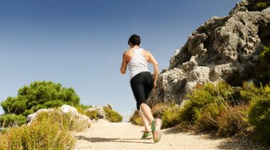 A person running up a hill, doing a hill running workout.