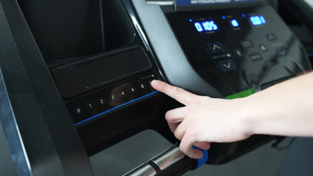 A hand reaches out to adjust the incline on a Horizon T101 Treadmill.