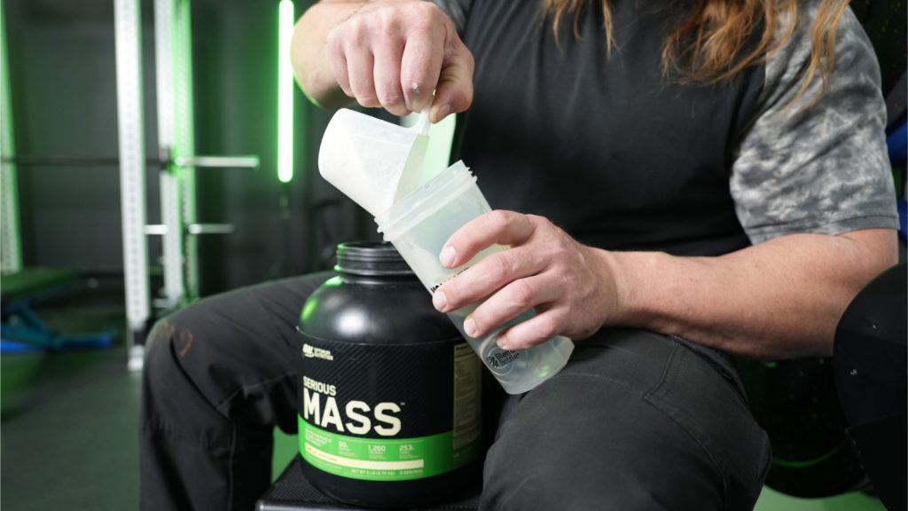 Our tester scooping the Optimum Nutrition Serious Mass into a shaker bottle.