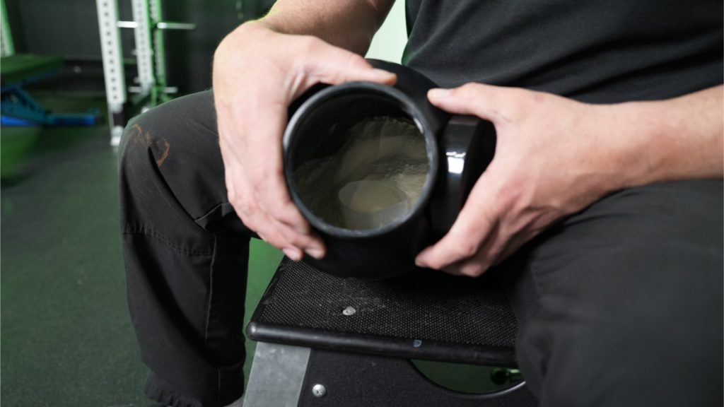 A BarBend tester displaying an open jar of mass gainer powder.