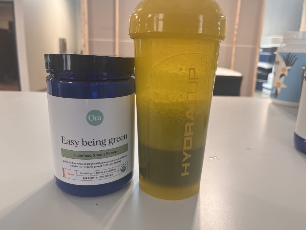 Ora Organic Greens with a shaker cup.