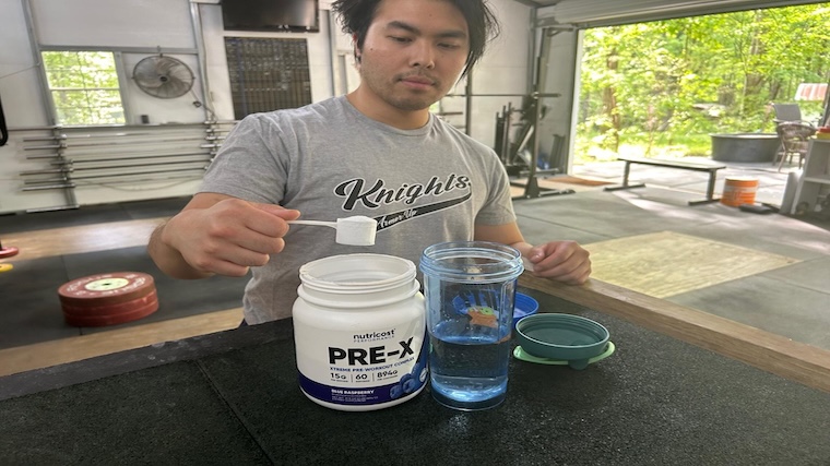 Our tester grabbing a scoop of Nutricost Pre-X Pre-Workout