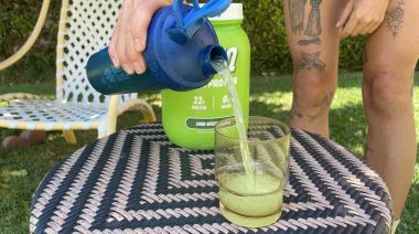 Pouring SEEQ into a glass from a blender bottle.