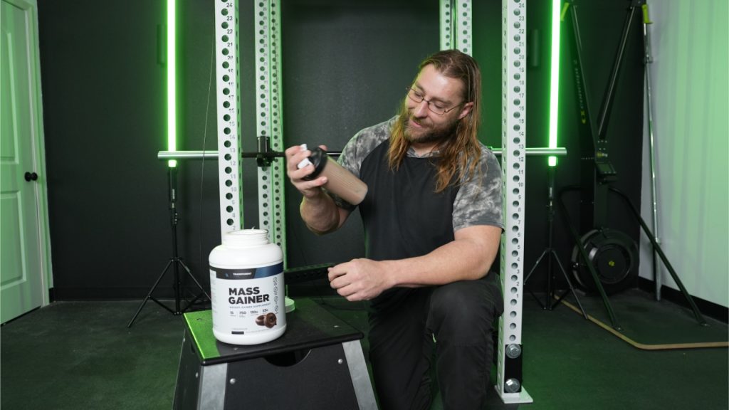 A BarBend tester shaking Transparent Labs mass gainer drink.