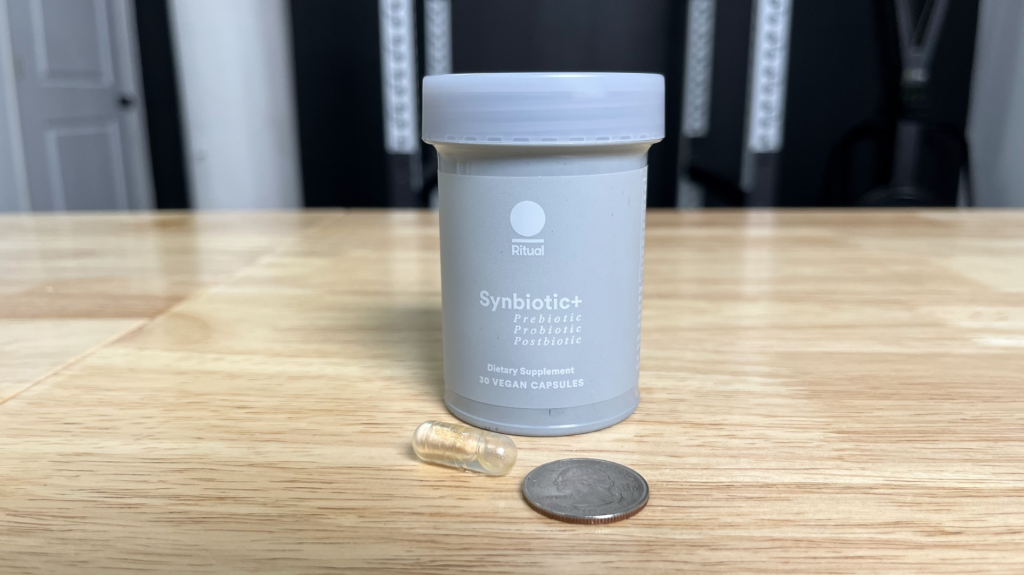 One Ritual Synbiotic+ probiotic pill (with quarter for scale)