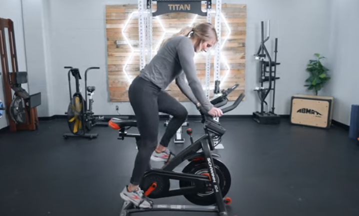 A BarBend tester riding a Schwinn IC4 exercise bike.